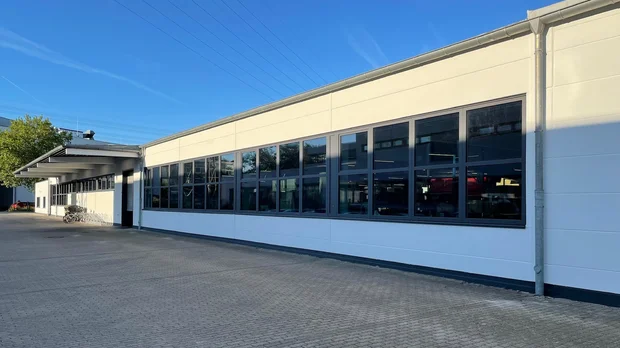 Fassadensanierung einer Industriehalle in Hamburg – moderne Erneuerung der Außenansicht Sanierte Fassade einer modernen Industriehalle mit großen Fenstern in Hamburg